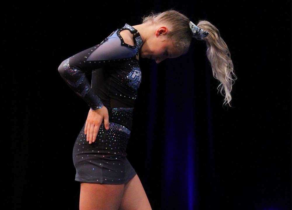 Cheerleader posed with her head down and hand on her hips