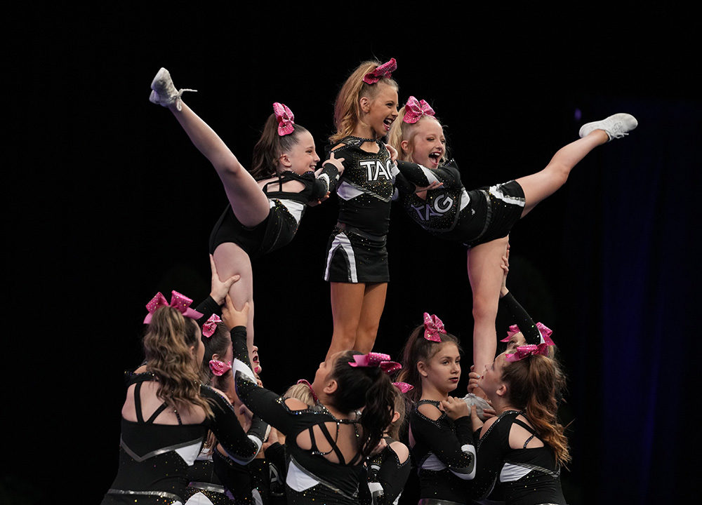 Youth team hitting their three stunt arabesque pyramid during a performance